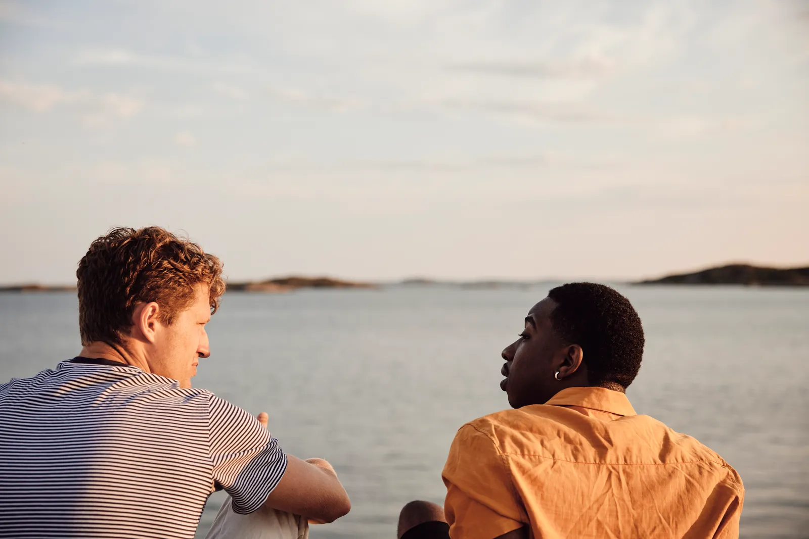 To unge i en rolig prat ved sjøen